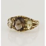 9ct yellow gold carved head three stone ring set with a central smoky quartz measuring approx.