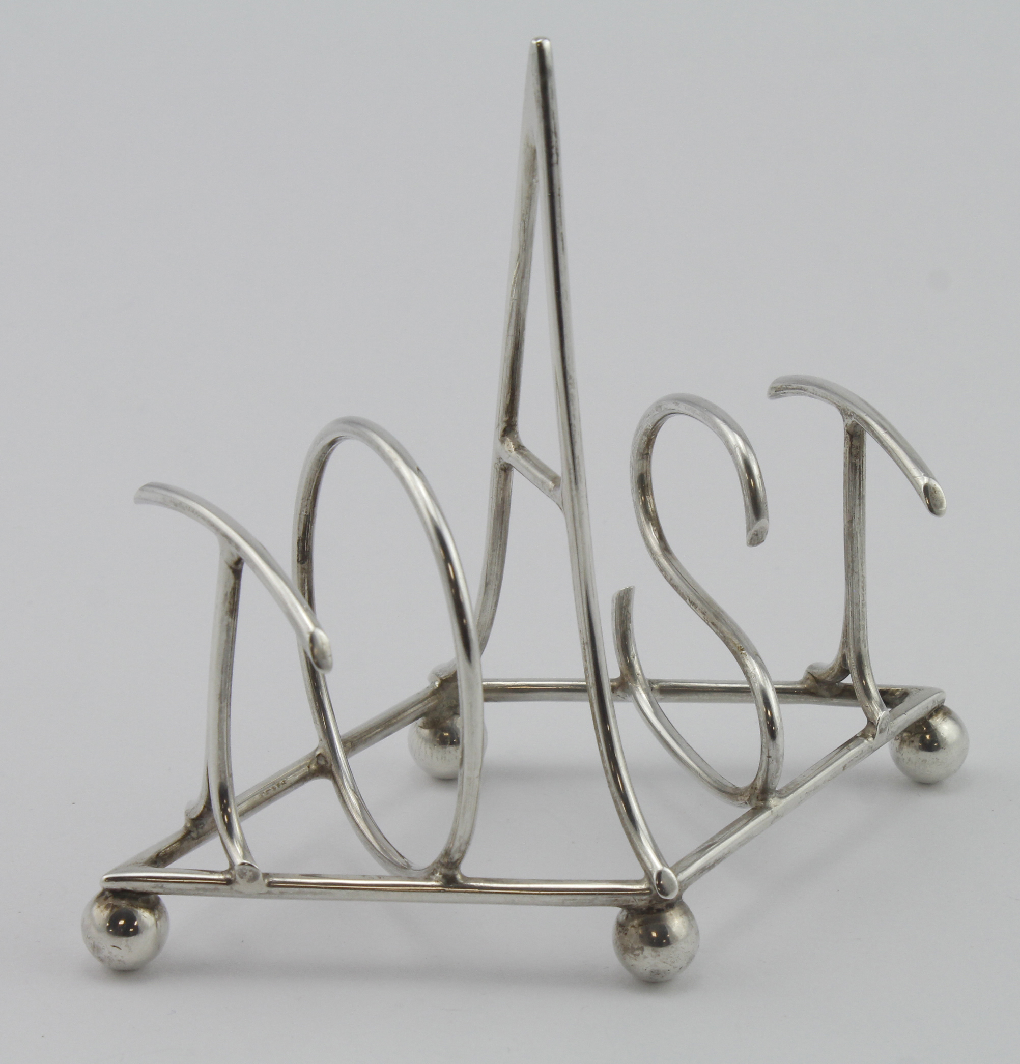 Hukin & Heath silver toast rack which reads "TOAST" in large silver letters, marked on the base with