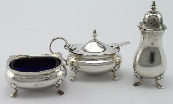 Silver three piece cruet set comprising a salt pot, mustard pot and pepper pot plus two blue glass