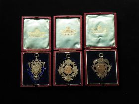 British Sporting Fobs (3) hallmarked silver, two with untested gold panels: Banbury Star Cyclists