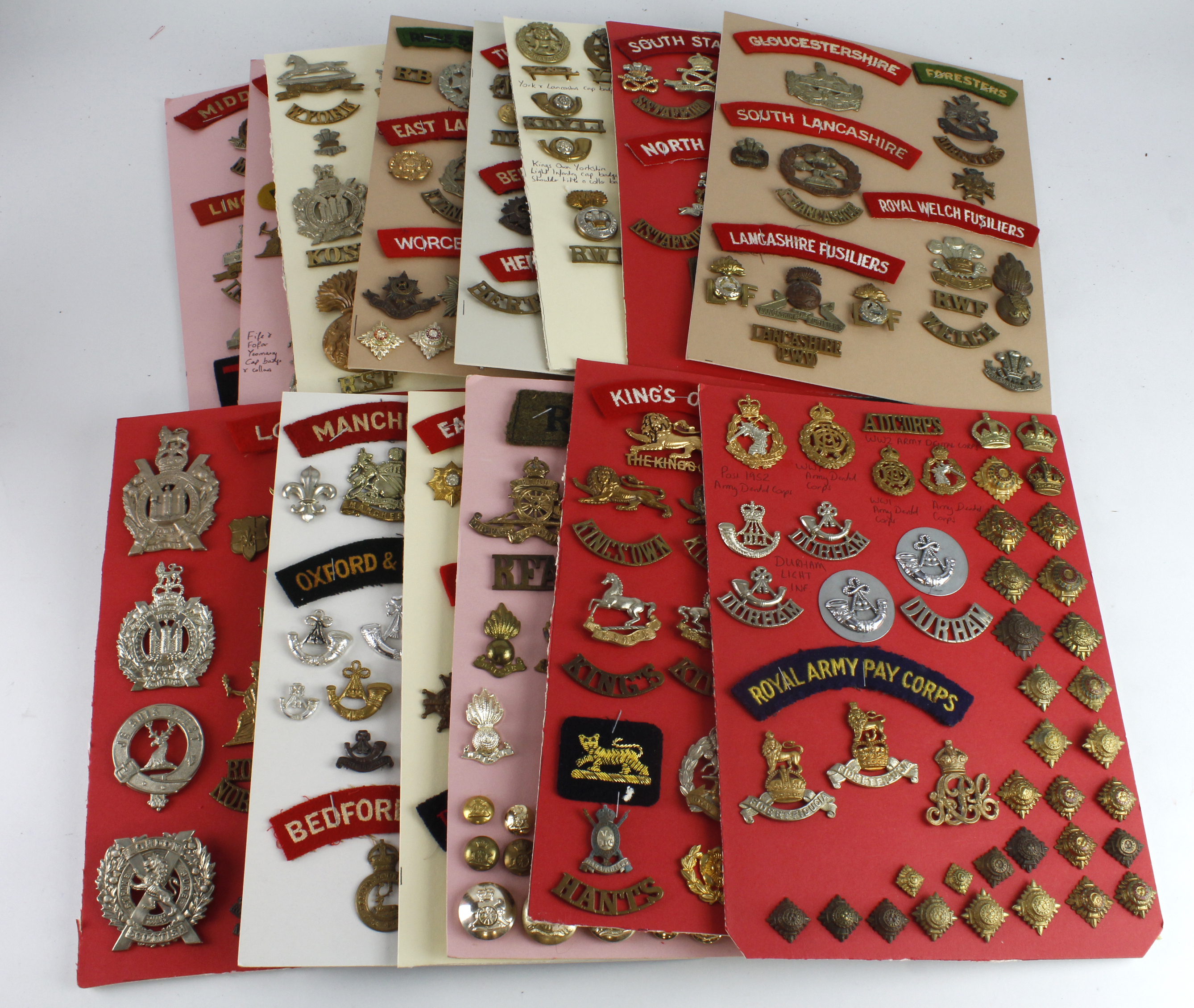 Cap badges / buttons / collars / metal and cloth title collection mounted on boards, wide range of