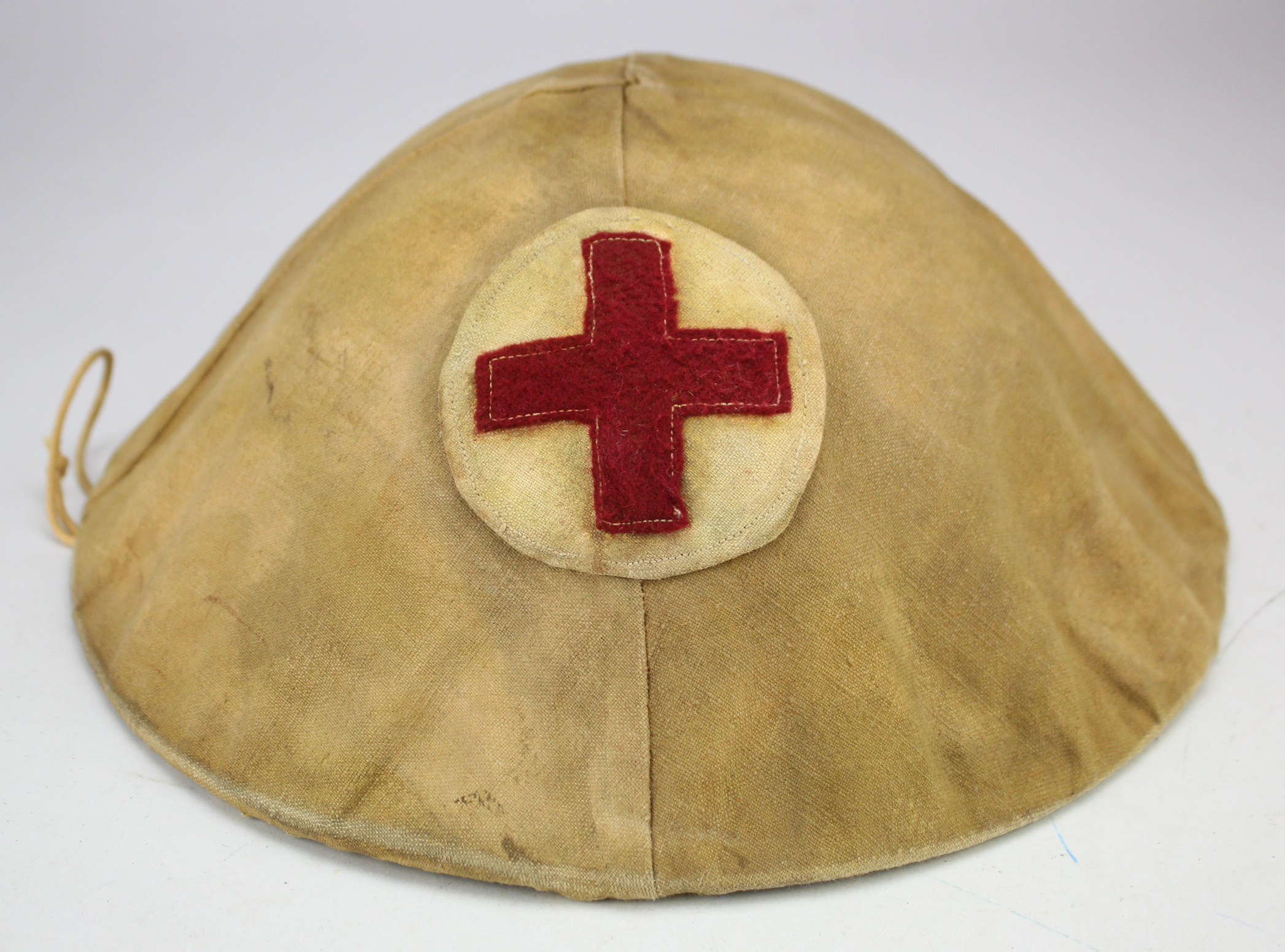 British WW1 Brodie steel helmet complete with liner and chin strap, with a cloth cover tied on, this