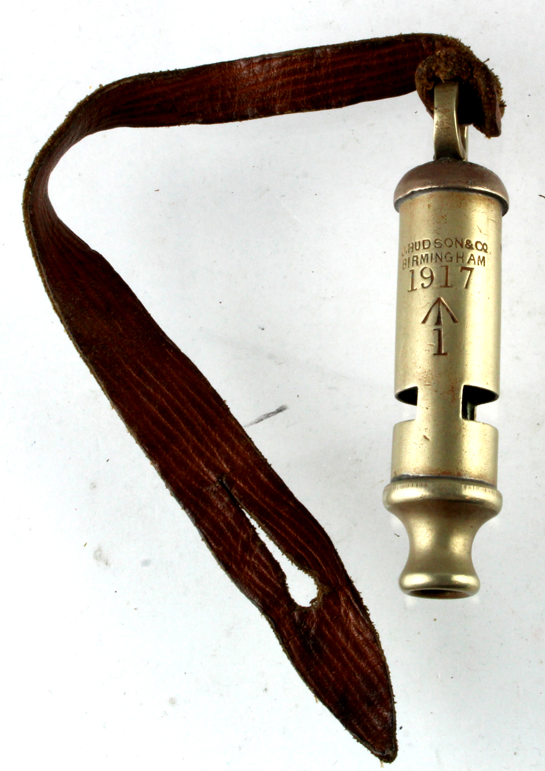WW1 1917 dated military marked trench whistle made by J Hudson of Birmingham with leather lanyard.
