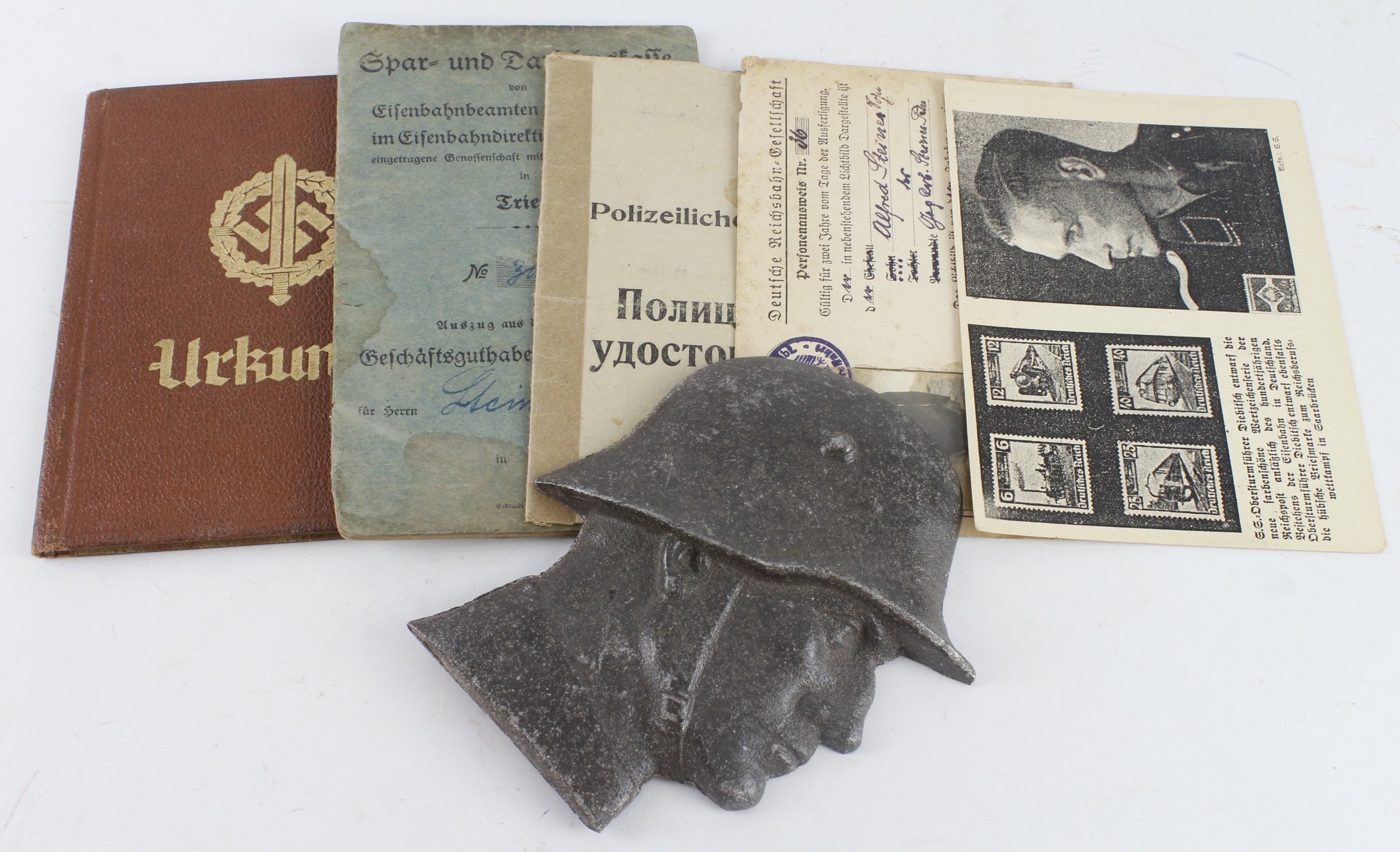German WW2 ID booklets, passes and a metal bust of a German soldier.