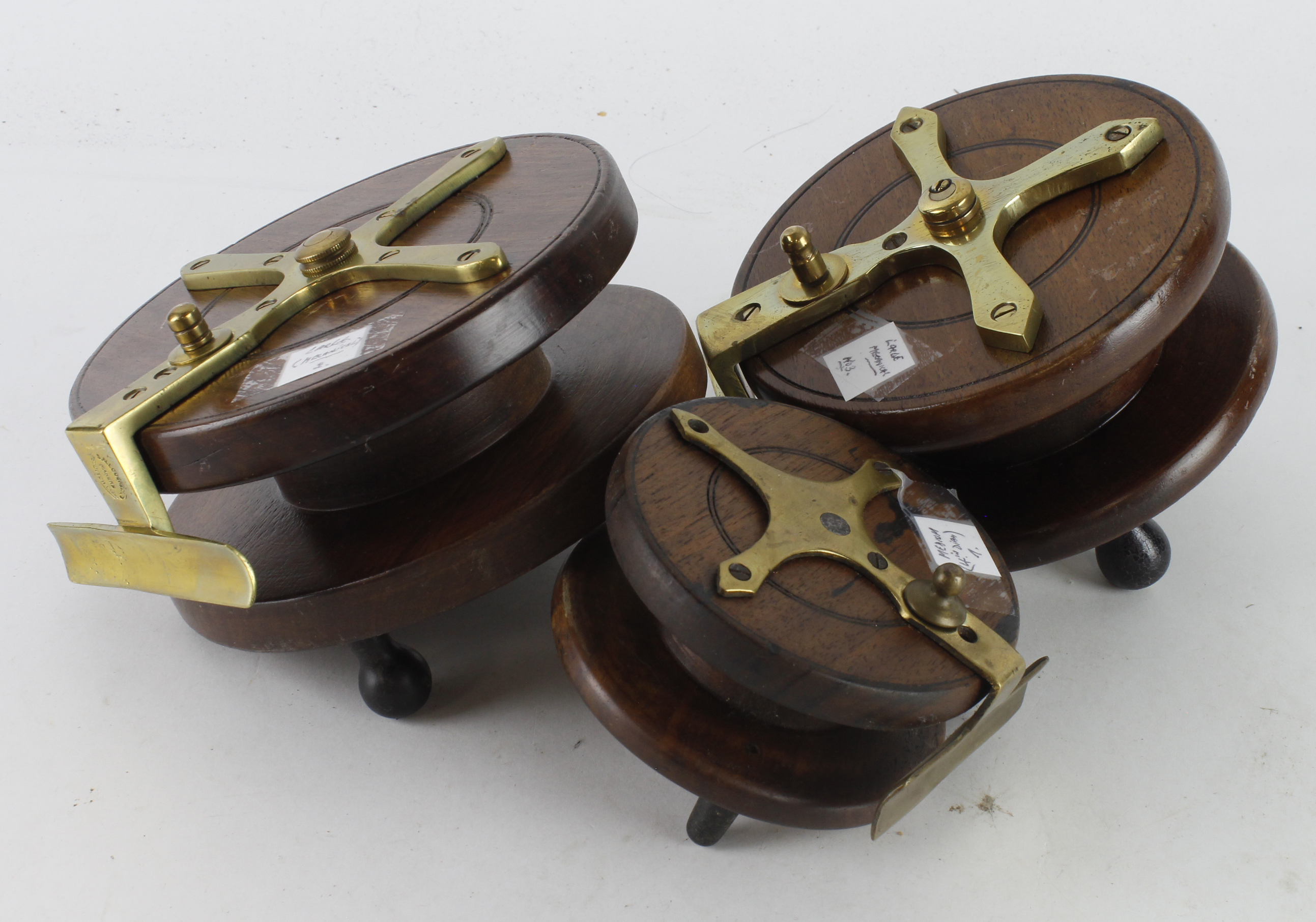 Fishing Reels. Three wooden fishing reels with brass mounts, including one stamped 'S. Allcock & Co.