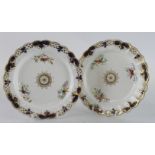 Two hand painted plates, decorated with butterflies, one plate with impressed diamond mark to