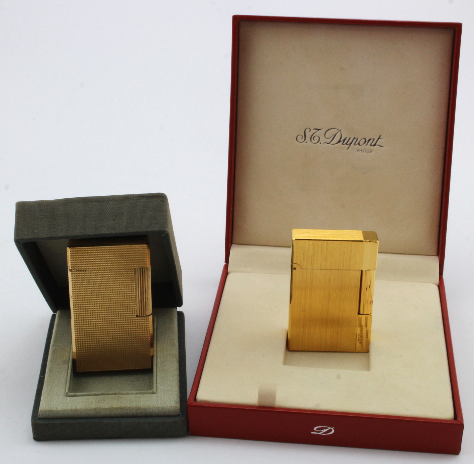 St. Dupont. Two gold plated lighters by S. T. Dupont, both contained in original cases