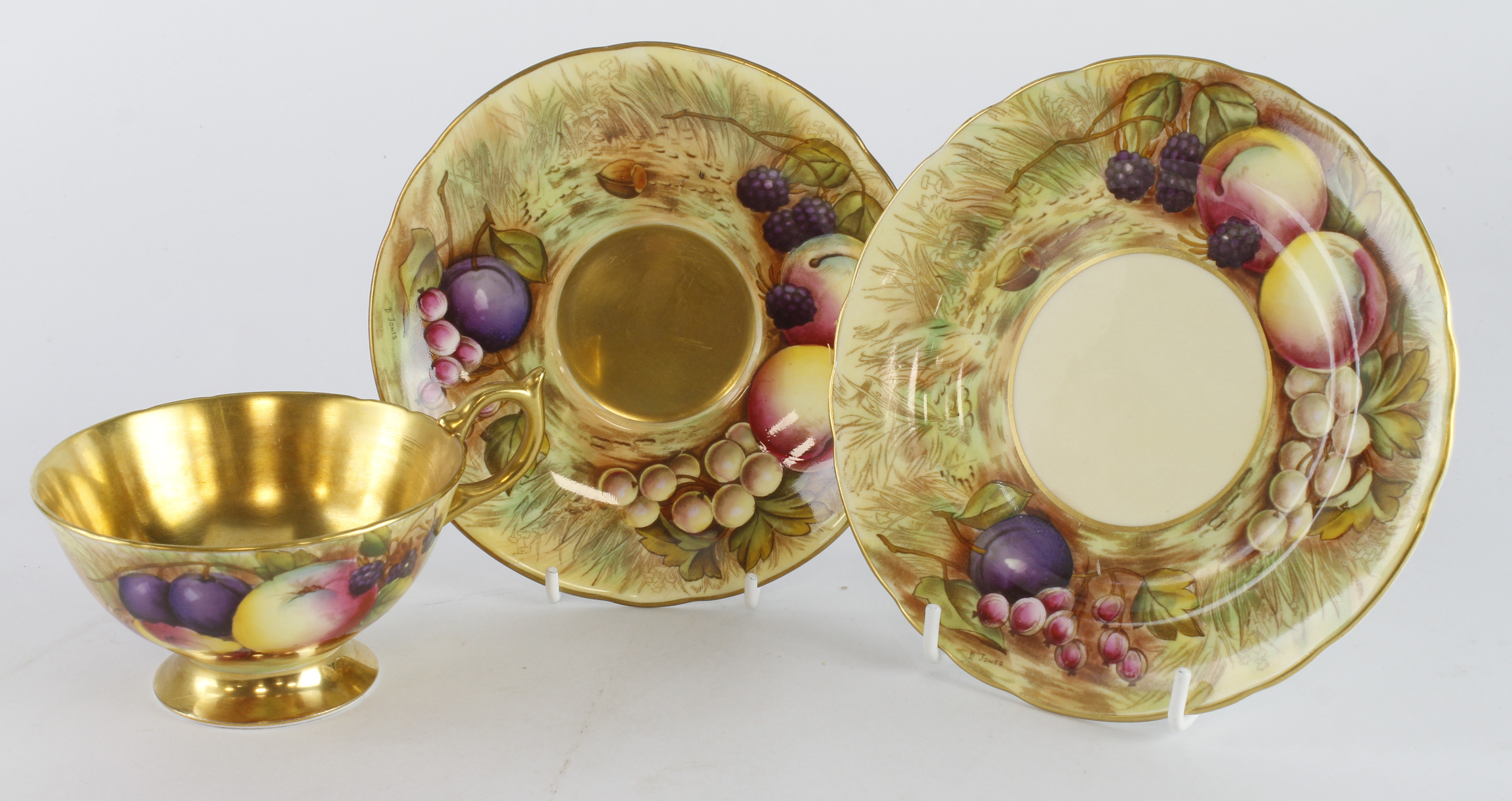 Aynsley trio, comprising cup, saucer and plate, plates both signed D. Jones, cup signed N. Brunt,