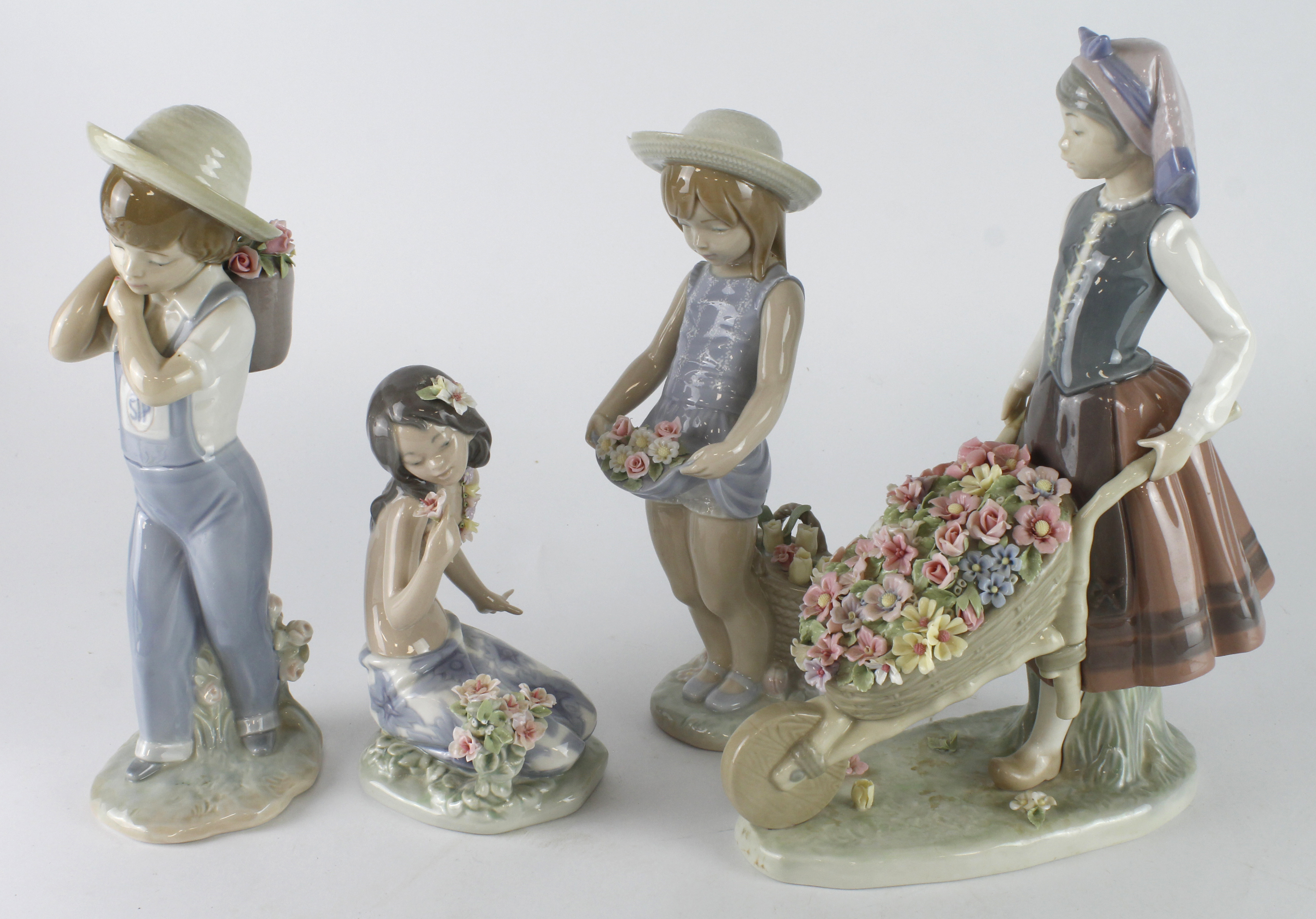 Lladro. Four Lladro figures, comprising a girl pushing a wheel barrow, a Hawaiian girl, and a boy