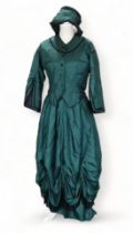 A re-enactment dress - in the form of a mid 19th century American woman, green satin with black