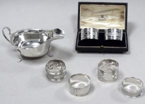 A silver sauce boat - Sheffield 1937, raised on three paw feet, together with a pair of boxed napkin