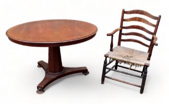 A Victorian mahogany loo table - the circular top above an octagonal tapering support and triform