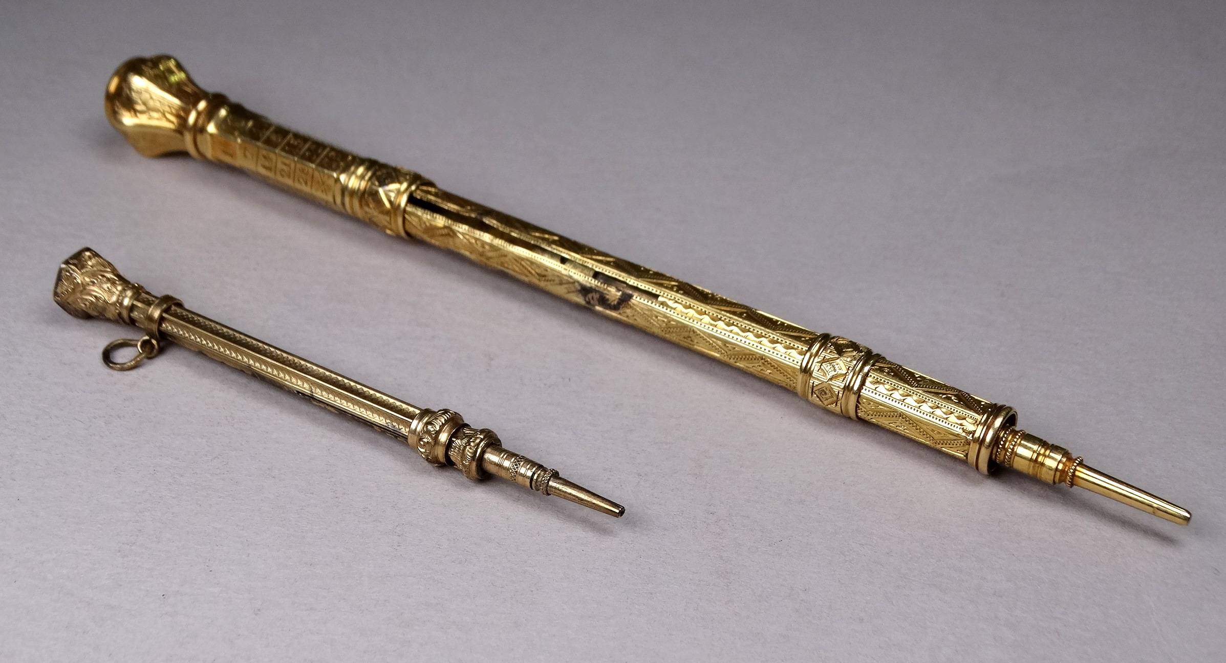 A 19th century gilt pen pencil - incorporating a French perpetual calendar to the top, with a