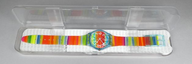 A child's Swatch watch - with rainbow colourway, with case and paperwork.