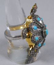 A large tortoise ring set with turquoise and diamonds and with ruby eyes - the turquoise weighing