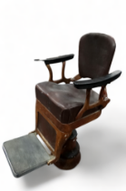 An early 20th century cast iron and upholstered dentist's chair - covered in brown rexine with a