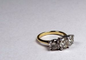 An 18ct yellow and white gold diamond three stone ring - the circular brilliant cut diamonds