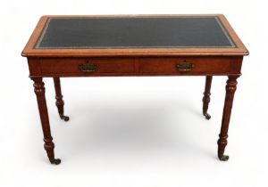 An Edwardian oak writing table - with a rectangular black leather inset top above an arrangement
