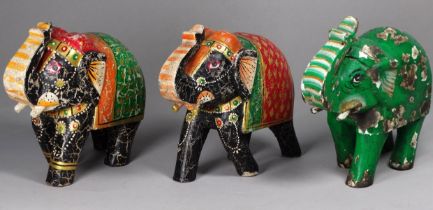 Three carved wood and polychrome painted elephants - trunks raised, each height 17cm.