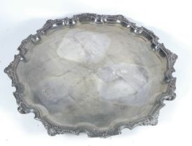 A silver tray - Sheffield 1978, Francis Howard Ltd, circular with a shaped cast rim, raised on three