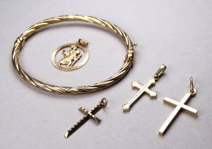 A 9ct gold bangle - of twisted oval form, together with three 9ct gold crosses and a St