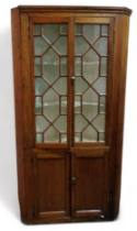 A 19th century pine standing corner cupboard - with a moulded cornice above a pair of astragal