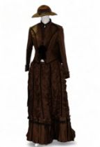 A re-enactment dress - in the form of a mid 19th century American woman, brown satin with velvet