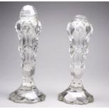 A pair of early 20th century cut glass cruets - of faceted baluster form (one lacking cover), height