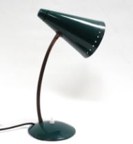 A vintage desk lamp - the green conical shade pierced with a band of stars to the mouth, on a