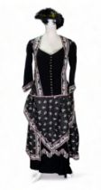 A re-enactment dress - in the form of a mid 19th century American woman, black with pink foliate