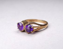 A 9ct gold amethyst ring - the twin stones claw set, size O, weight 4.1g.