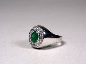 An 18ct white gold emerald and diamond set cluster ring - the central oval emerald of 1.70ct