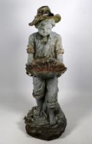 A cast resin figure of a boy gardener - holding a shell and wearing a hat, raised on a square column