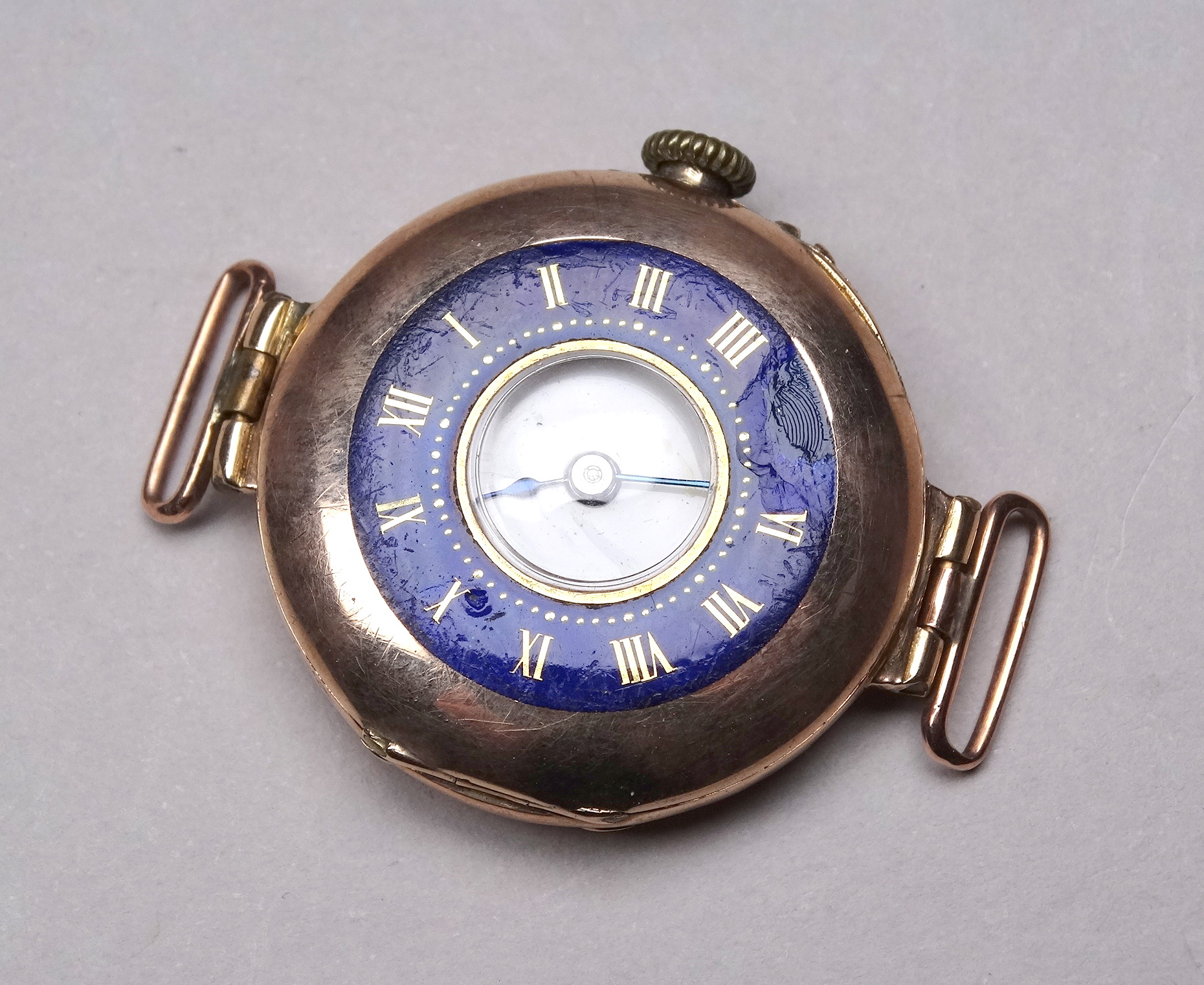 An early 20th century 9ct gold cased wristwatch - with a white enamel chapter ring set out in
