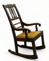 A late 19th century walnut rocking chair - with vase shaped splat, open arms and slip-in seat.