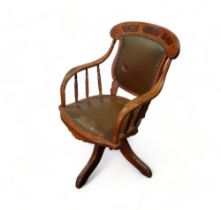 An early 20th century oak swivel chair - the top rail with fancy veneer panels above a pad back