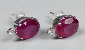 A pair of platinum ear studs set with rubies and diamonds - the oval rubies weighing 3.00ct