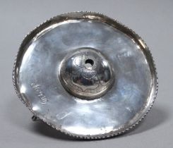 A circular white metal dish - the center boss engraved with flowers, raised on short cabriole