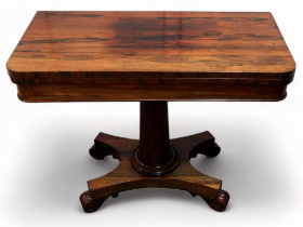 A William IV rosewood card table - the rectangular fold-over top above a turned columnar support and