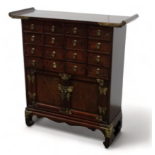 A 20th century Chinese elm table cabinet - of typical form with an arrangement of sixteen drawers