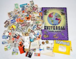 A quantity of world stamps - some in an album, others loose or attached to part envelopes. (qty)