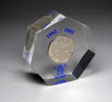 A Royal Mint dual date 50 pence - resin encased as a paperweight.