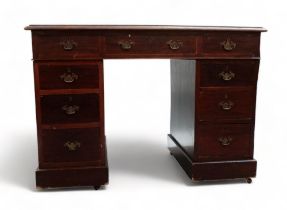 An early 20th century mahogany pedestal desk - the rectangular top with writing inset above three