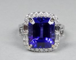 An 18ct white gold ring set tanzanite and diamonds - the central step cut tanzanite weighing 7.