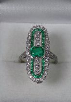 A platinum emerald and diamond set ring - the emerald and calibre cut emeralds weighing 0.73ct