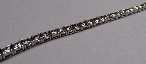 An 18ct white gold diamond line bracelet - set circular brilliant cut diamonds weighing 7ct