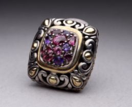 A silver and 18ct gold mounted amethyst set clip - cushion shaped on a pierced foliate ground,