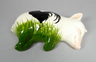 A Wemyss Griselda Hill pottery pig - recumbent, decorated with a black hen, width 17cm.