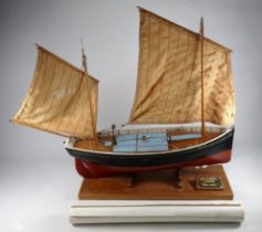 A model of a Mevagissey lugger - black and red below the waterline, mounted on a rectangular base,