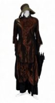 A re-enactment dress - in the form of a mid 19th century American woman, brown satin with lace trim,